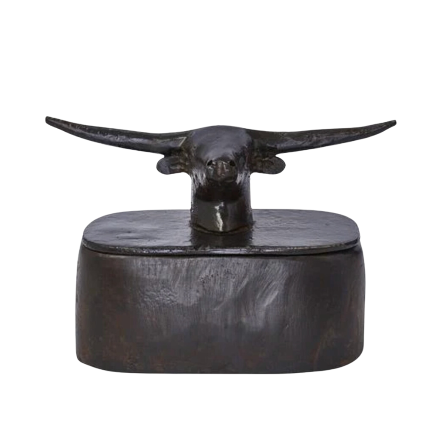 Elevate your home decor with the Jan Barboglio Premio Toro Box. This beautiful handcrafted box is made from wax cast iron and features a magnificent longhorn atop the box. The box is lined with a leather saddle insert, this box can hold a variety of items, from office supplies and accessories to jewelry and cuff links. Handcrafted decorative box. Longhorn topper. Saddle leather insert. Dimensions: 5" x 3" x 4". Care: Clean with a soft, dry cloth.