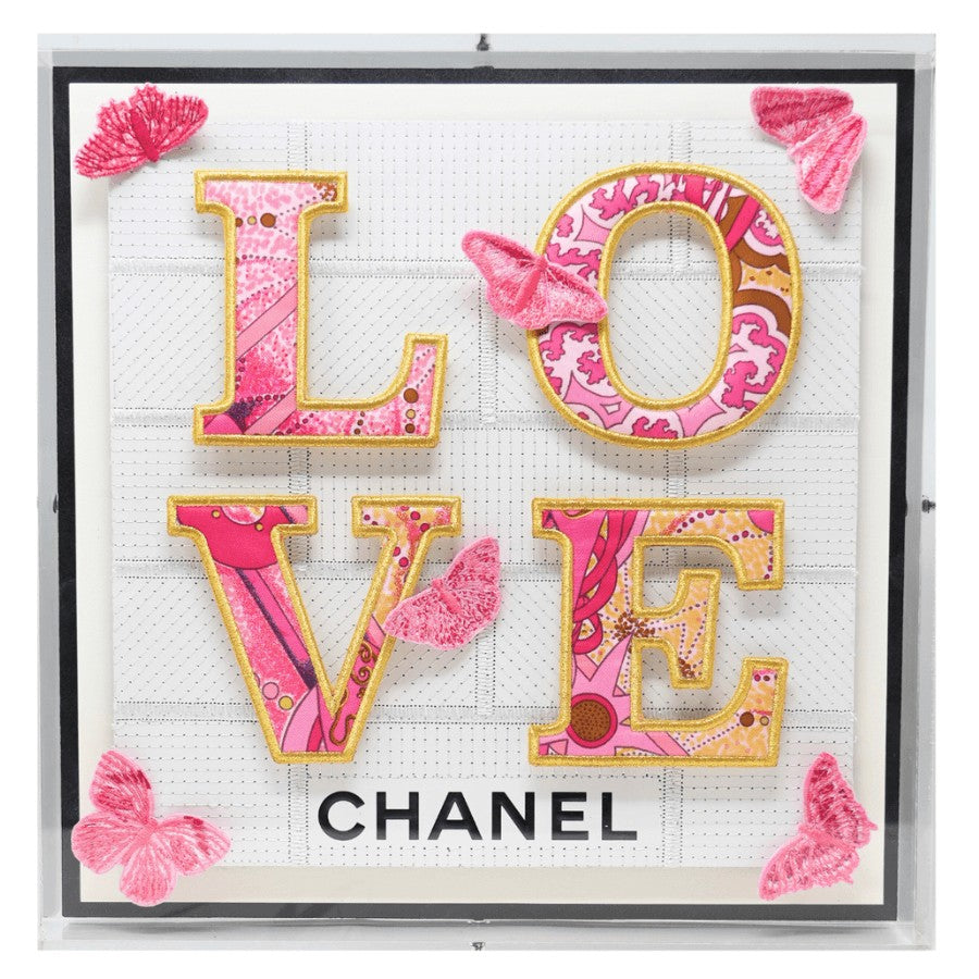 The Love pieces start with a background created from luxury boxes and bags that have been deconstructed and then directly embroidered. The typography is created using a luxury brand silk scarf that is embroidered, appliquéd, and then mounted in relief to the background. The butterflies are all individually embroidered to harmoniously blend with the scarf colors and are mounted in relief for a dimensional effect. 12" x 12" x 2" in size. The art comes framed in acrylic and is signed and numbered by the artist