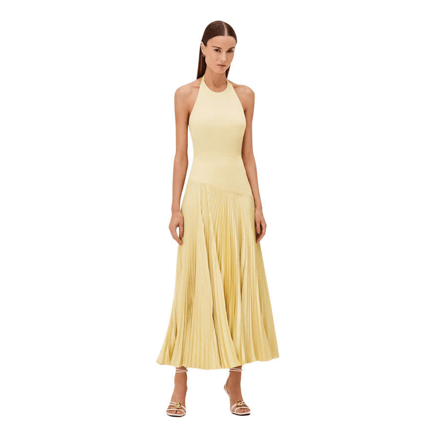 The Saab Dress, with its halter neckline, invites a modern twist to the classic silhouette. This dress features a beautifully pleated skirt that creates a soft, flowing movement, accentuated by an asymmetrical hem. Perfect for your next event. It pairs seamlessly with delicate sandals, embodying a sophisticated yet fresh style.