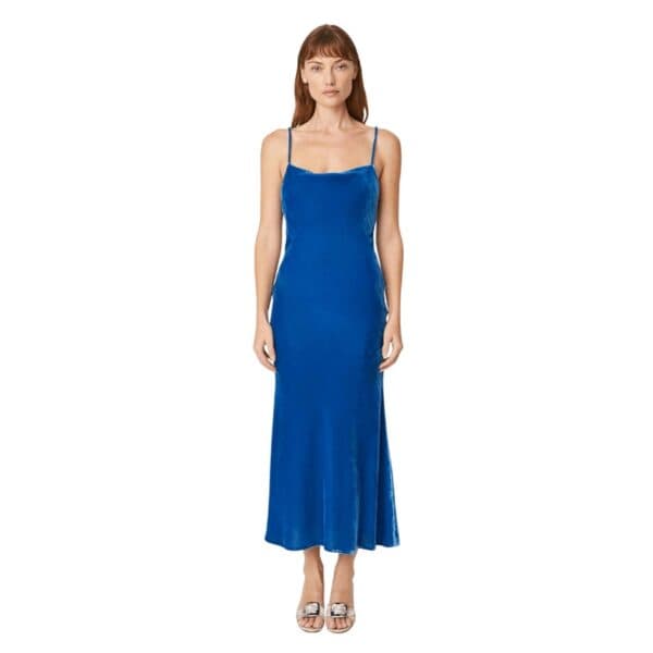 The Jemima dress is an elegant, figure-flattering full-length dress that brings a sensual femininity to any occasion. With a cowl neck, thin straps, and low back with a tie detail, Jemima is reminiscent of the simple ’90s silhouette. Made from rich royal blue velvet, it’s finished with a luxe celebratory spirit. Wear it from day to night with simple strappy heels or a knee high boot for all the season’s festivities.