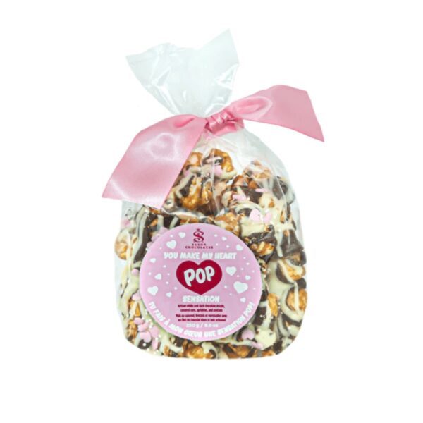 Saxon Chocolate's gourmet Pop Sensation drenched in Couverture chocolate sprinkled with LOVE! Enjoy this crunchy caramel popcorn covered in dark and white chocolate with a lovely mixture of pretzels, mini sugar pink heart sprinkles, and white mini pearls.  The popcorn is packaged in a clear bag with a Saxon Chocolates sticker on the front and a pink satin ribbon to secure. Weight per unit: 250g / 8.8oz. Size per unit: 4.5" x 2.5" x 8.5". Units per case: 8. Shelf life: 9 months.
