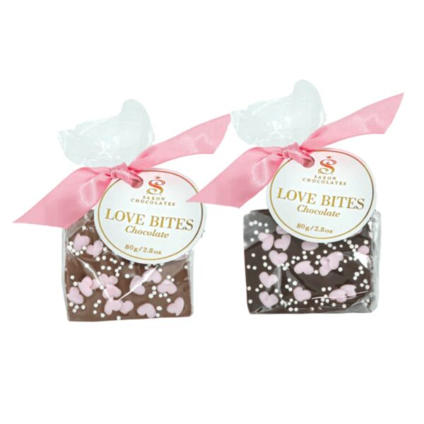An assortment of milk and dark chocolate barks sprinkled mini sugar pink hearts and white mini pearls. Each bark bag includes three pieces packaged in a clear bag with a pink satin ribbon and a branded tag.   80g / 2.8oz. Shelf life - 12 months.